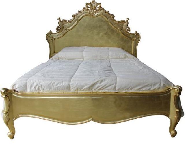 An ornate gold bed frame with a high carved headboard and matching footboard, shown with white bedding on a plain white background.